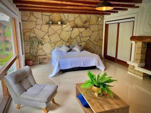 a bedroom with a bed and a chair at Luxury Villa In Provenza in Medellín