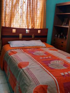 uma cama com uma colcha num quarto em Acogedor departamento em Loja