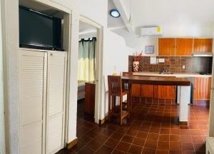 a kitchen with a table and a tv in a room at Suites Acapulco Yamba in Acapulco