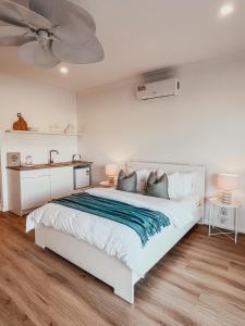 um quarto com uma cama branca e uma ventoinha de tecto em Harrington Guest Suite em Harrington