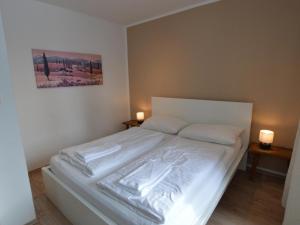 um quarto com uma cama branca com duas luzes em duas mesas em Sonnleiten 1 em Hinterthal