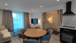 een woonkamer met een houten tafel en stoelen bij Soleil Levant - Standing T3 avec parking in Cassis