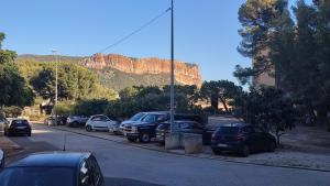 een parkeerplaats met auto's geparkeerd voor een berg bij Soleil Levant - Standing T3 avec parking in Cassis