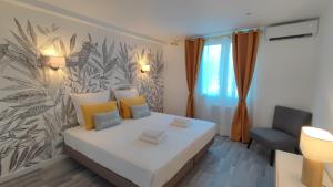 een kleine kamer met een bed en een stoel bij Soleil Levant - Standing T3 avec parking in Cassis