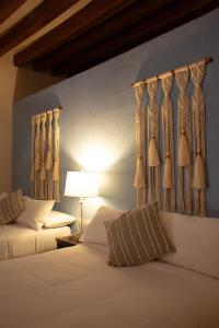 a bedroom with two beds and a lamp and curtains at Casa Montespejo B&B in Querétaro