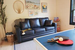 a living room with a leather couch and a table at Whispering Pines - Indoor Pool, Hot Tub, Fire Pit in Sevierville