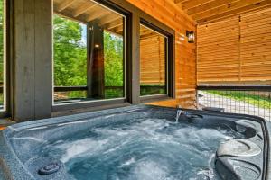 a jacuzzi tub in a room with windows at Whispering Pines - Indoor Pool, Hot Tub, Fire Pit in Sevierville