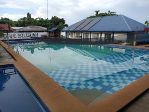 a swimming pool with a house with a blue roof at Agta Beach Resort in Biliran