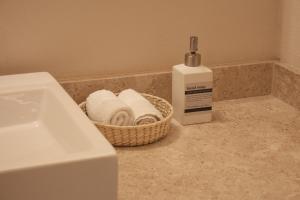a bathroom counter with a basket of towels and a bottle of soap at Casa Montespejo B&B in Querétaro +69 photos