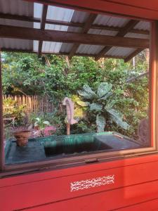 a window with a miniature sink in a garden at Hospedagem Casinha do Solar in Soure