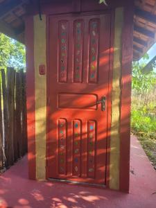 a wooden door with a red door at Hospedagem Casinha do Solar in Soure