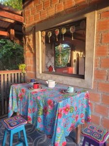 a table with two chairs and a tablecloth with flowers at Hospedagem Casinha do Solar in Soure