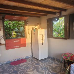 Una nevera blanca en una habitación con 2 ventanas en Hospedagem Casinha do Solar, en Soure