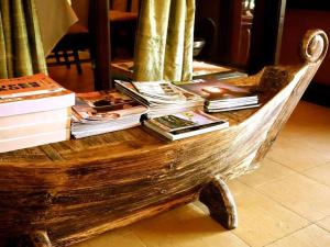Maison Arnica Hotel & Restaurant في بنوم بنه: كومة من الكتب موضوعة على كرسي خشبي