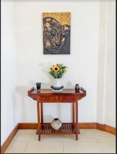 un tavolo di legno con un vaso di fiori sopra di Maison Arnica Hotel & Restaurant a Phnom Penh