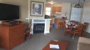 a living room with a television and a fireplace at GetAways At Haliburton Heights in Haliburton