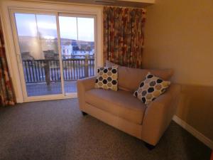 a couch with two pillows sitting in front of a window at GetAways At Haliburton Heights in Haliburton
