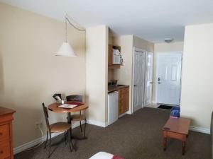 a room with a desk and a table and a kitchen at GetAways At Haliburton Heights in Haliburton