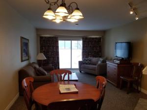 a living room with a table and a television at GetAways At Haliburton Heights in Haliburton