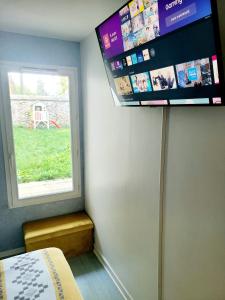 a room with a window and a tv on the wall at Résidence du Lac-Disneyland Paris-TARIF FAMILIAL in Émerainville