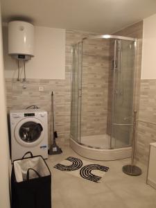 a bathroom with a shower and a washing machine at Apartment Nadalina in Kraljevica