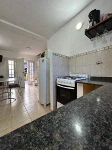 a kitchen with a white refrigerator and a table at Cabañas del Duende El Volcan in El Volcán