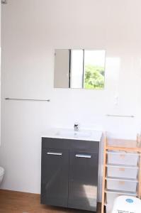a bathroom with a sink and a mirror at Casa das Hortênsias - Beach House in Porto Formoso