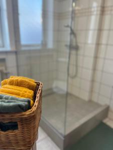 a basket of towels in a bathroom with a shower at Flóki by Guesthouse Reykjavík in Reykjavík