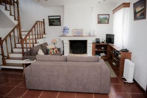 a living room with a couch and a fireplace at Casa das Hortênsias - Beach House in Porto Formoso