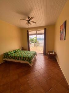 - une chambre avec un lit et un ventilateur de plafond dans l'établissement Te Mana Lodge, à Taravao