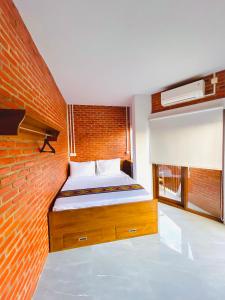 1 dormitorio con 1 cama con pared de ladrillo en Puu Pau Hotel & Coffee Shop en Labuan Bajo