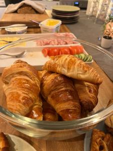 - une plaque de verre de viennoiseries et de croissants sur une table dans l'établissement Flóki by Guesthouse Reykjavík, à Reykjavik