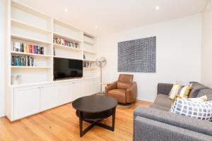 a living room with a couch and a table and a tv at Surry Hills Terrace in Sydney