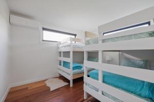 - une chambre avec des lits superposés dans une maison dans l'établissement Smiths Island Retreat, à Smiths Beach