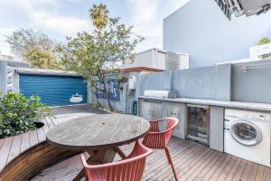 a patio with a wooden table and chairs and a washing machine at Surry Hills Terrace in Sydney