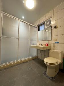 a bathroom with a toilet and a shower and a sink at Jeanette Home in Xizhi