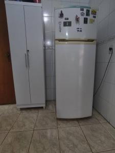 uma pequena cozinha com um frigorífico branco e armários em Quarto Privado em Franca
