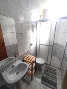 uma casa de banho com um lavatório, um WC e um chuveiro em Quarto Privado em Franca