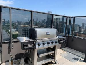 a grill on a balcony with a view of the city at Beautiful 1Bd Entertainment disrtrict. in Toronto