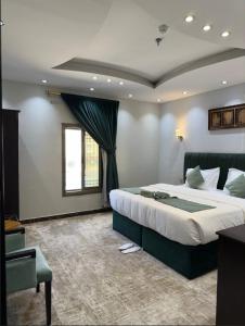 Un dormitorio con una cama grande y una ventana en فندق زوايا الماسية فرع الحمراء en Medina