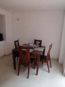 een eettafel met 2 stoelen en een tafel met een stoel bij Casa la Alborada in Jamundí