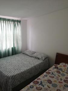 niewielka sypialnia z 2 łóżkami i oknem w obiekcie Casa la Alborada w mieście Jamundí