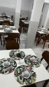 a dining room with tables with plates and glasses at Zuppolini Garden Hotel Oficial in Bananeiras