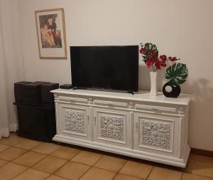 a white entertainment center with a television on top of it at Apartamento Vista Mar - 2 Garagens in Guarujá