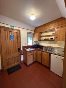 a large kitchen with wooden cabinets and a door at Masterton Motor Lodge in Masterton