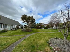 a path in a yard next to a house at Masterton Motor Lodge in Masterton