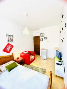 a bedroom with a bed and a red chair at Milz house in Salé