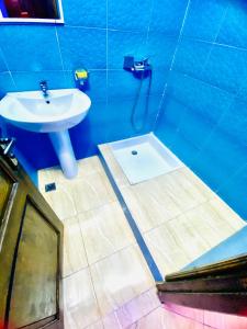 a blue bathroom with a sink and a shower at Milz house in Salé
