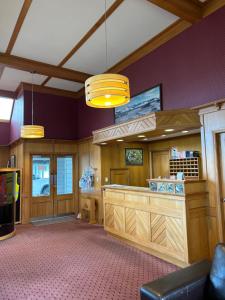 a restaurant with a counter in a room with purple walls at Masterton Motor Lodge in Masterton