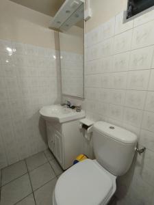 een witte badkamer met een toilet en een wastafel bij Gîtes Plais'Anse in Trois-Rivières